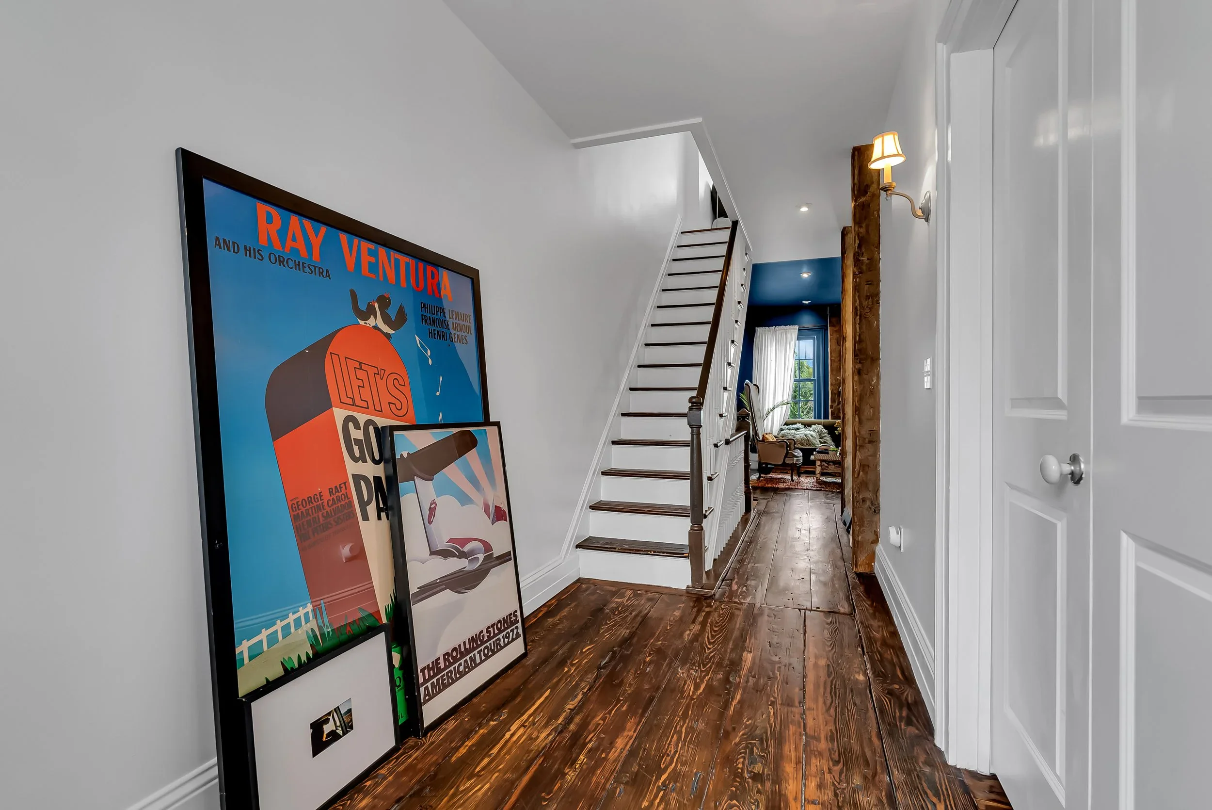 Historic hallway and staircase lined with framed photographs and family ephemera