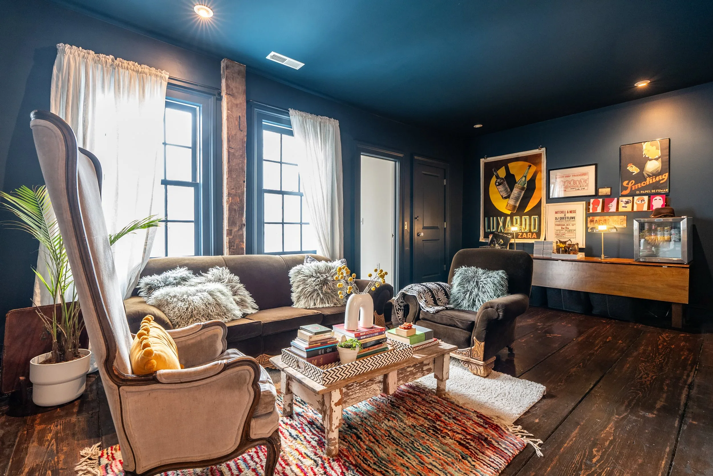 Relaxed lounge corner with a deep sofa, throw blankets, and shelves of books and travel treasures